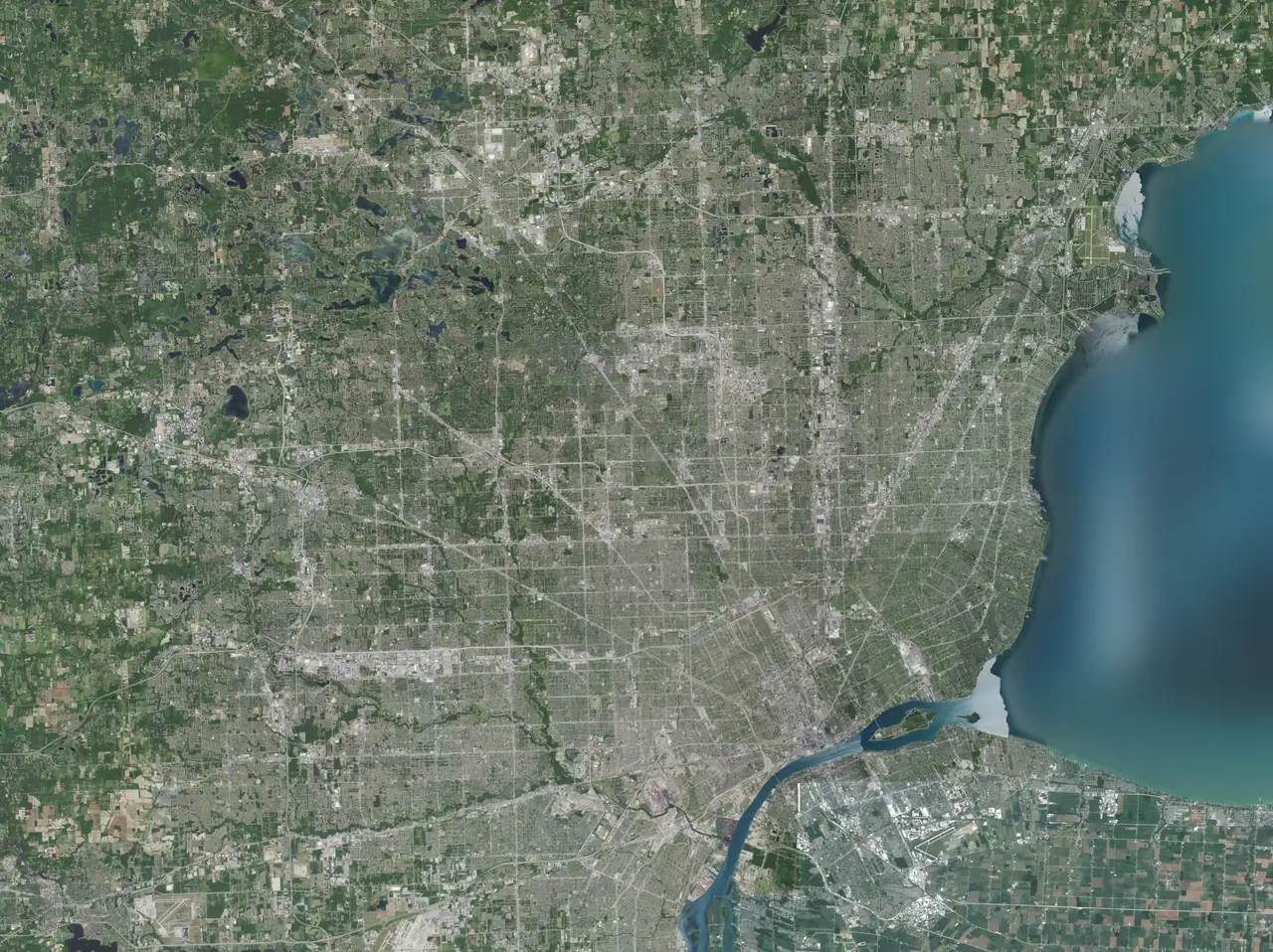 Satellite map of Metro Detroit with the service area outlined: from Shelby Township and Rochester Hills in the north to Canton and Dearborn in the south, and from Novi and Northville in the west to Grosse Pointe on Lake St. Clair in the east. Detroit is marked on the Detroit River.