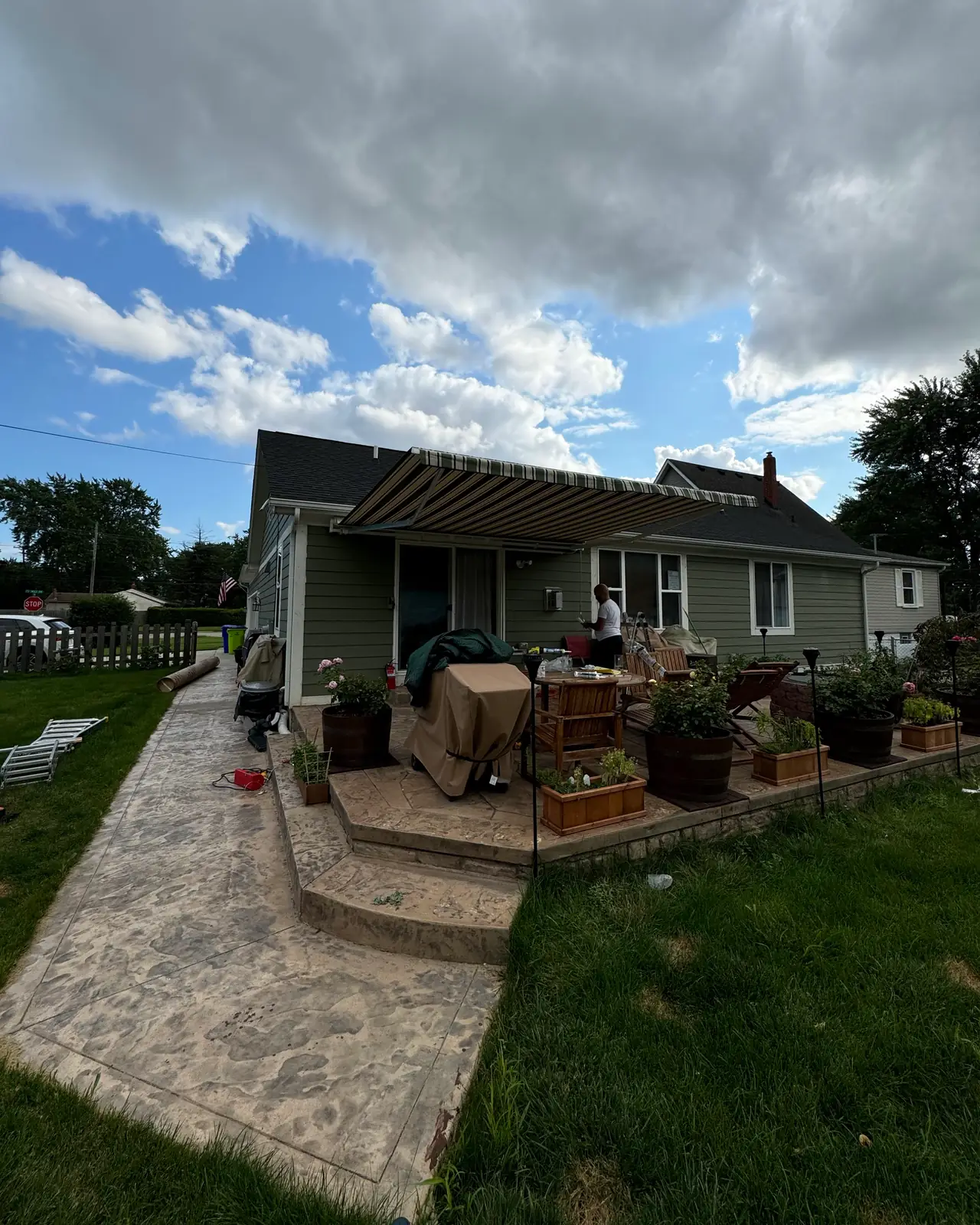 Backyard with a stamped concrete walkway, raised patio and pergola