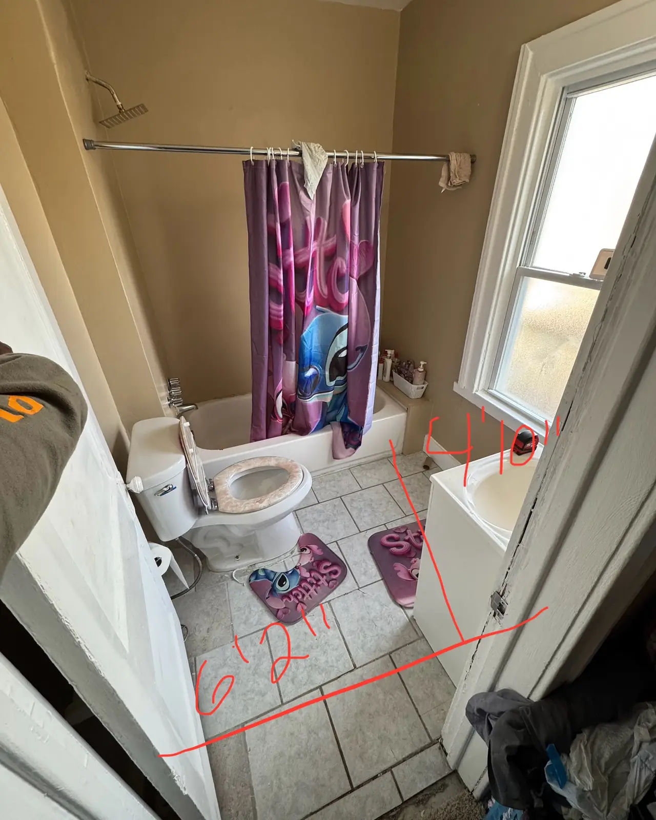 Small bathroom with a tub, shower curtain and toilet, marked with handwritten measurements, before