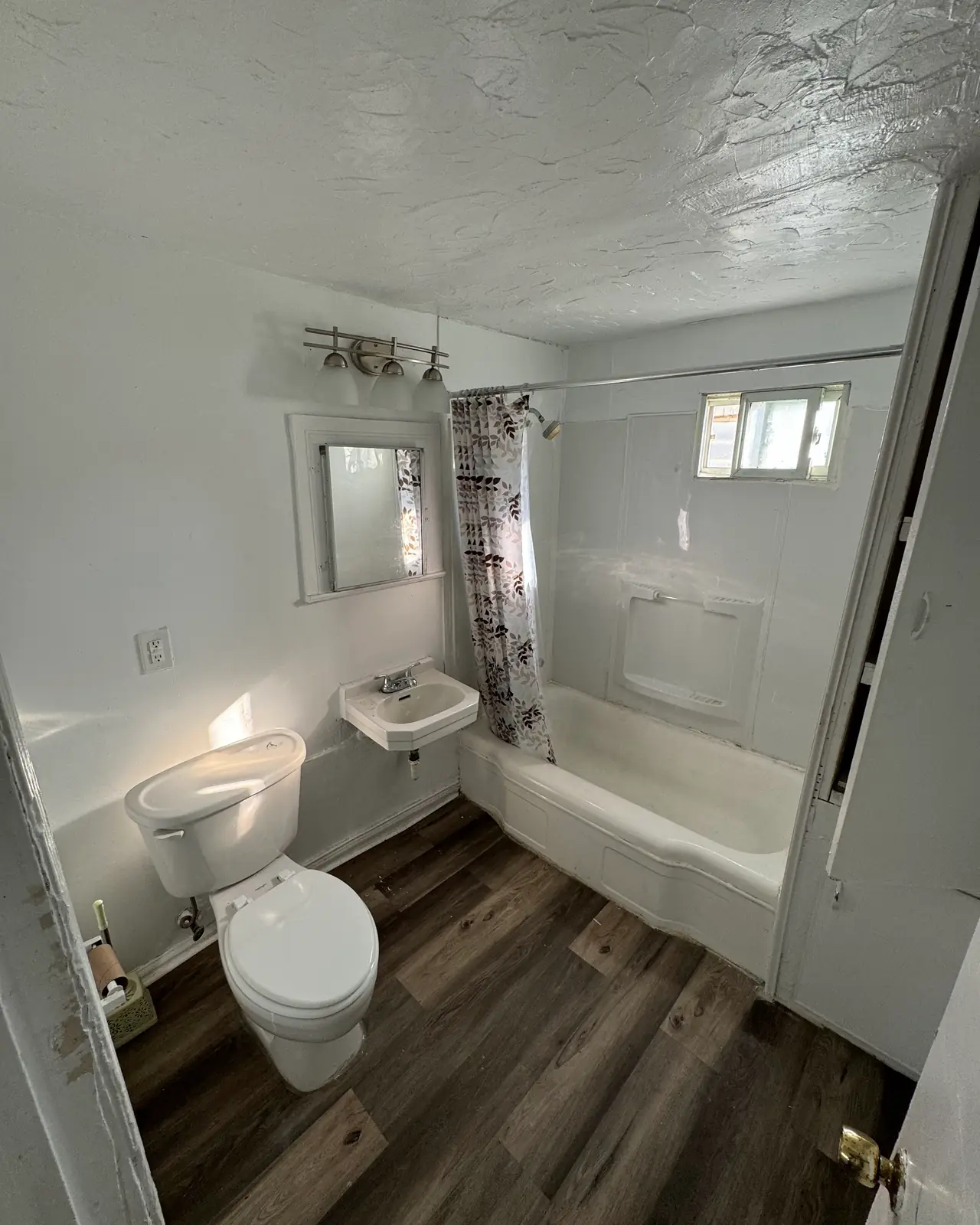 Bathroom with pedestal sink, toilet and tub with shower curtain, before
