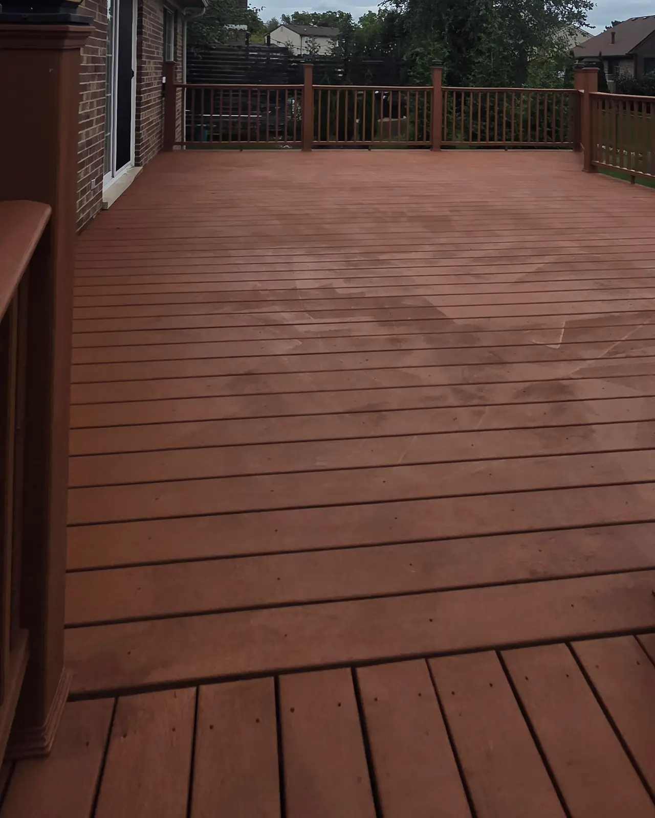 Same deck with evenly stained boards and railings