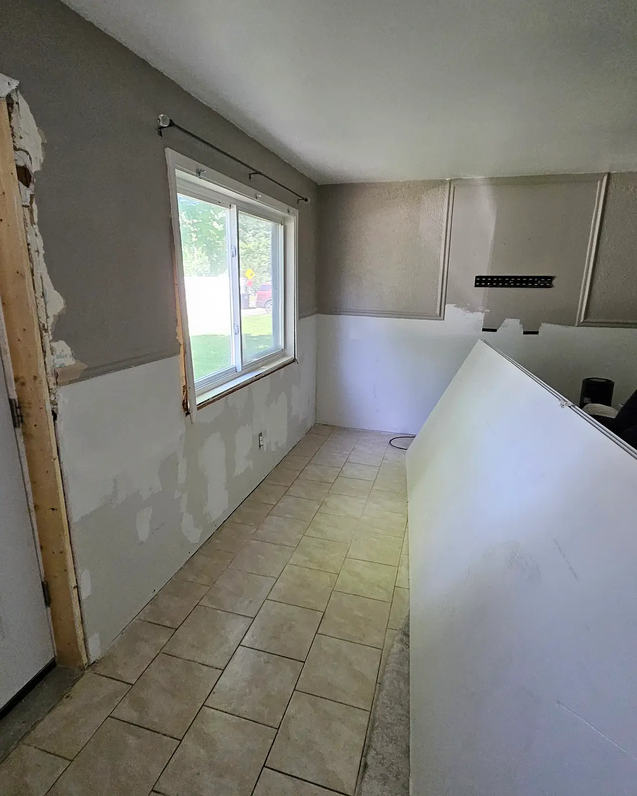 Same room with new drywall hung on the lower walls