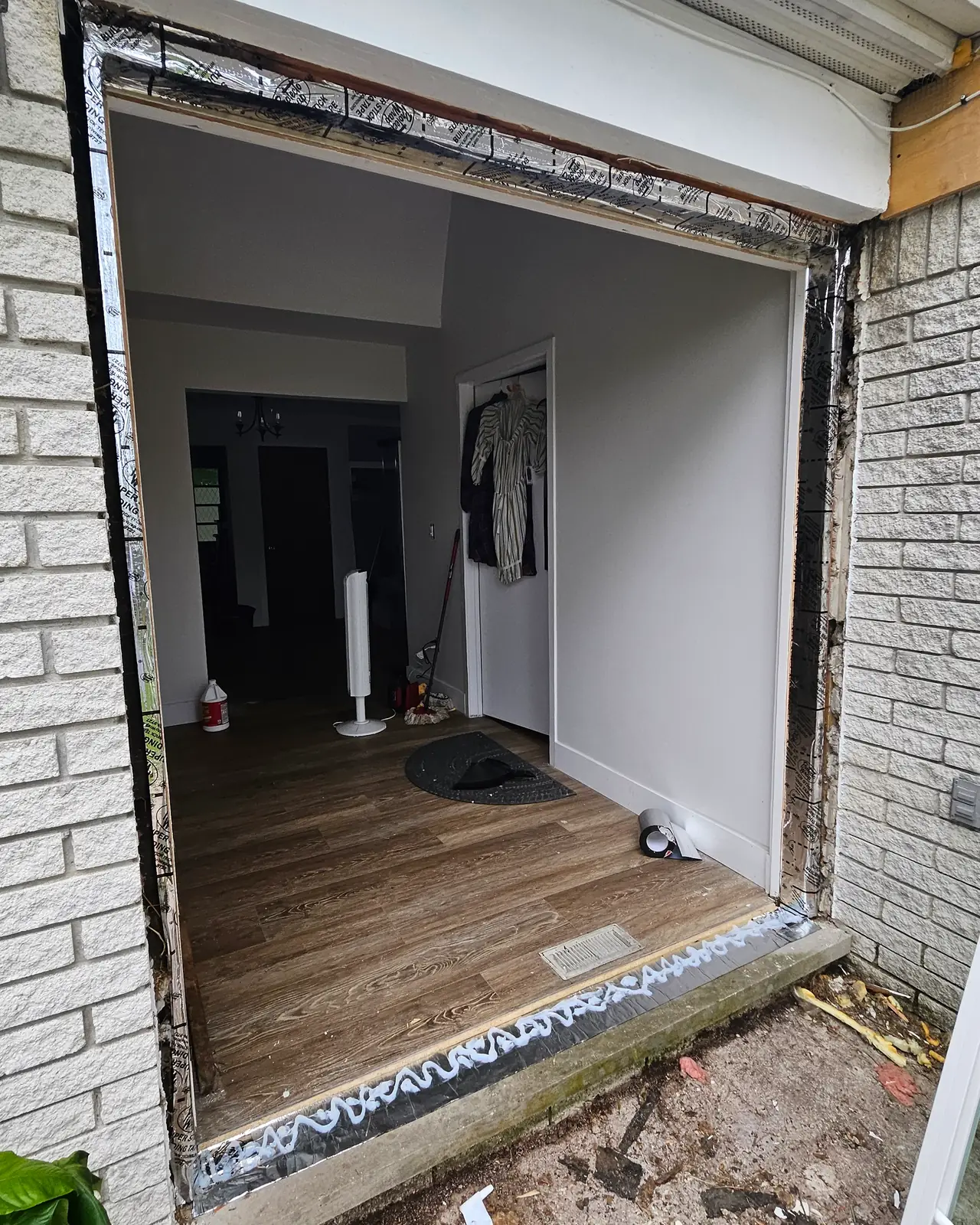 Brick wall with the old door removed and the opening exposed, before