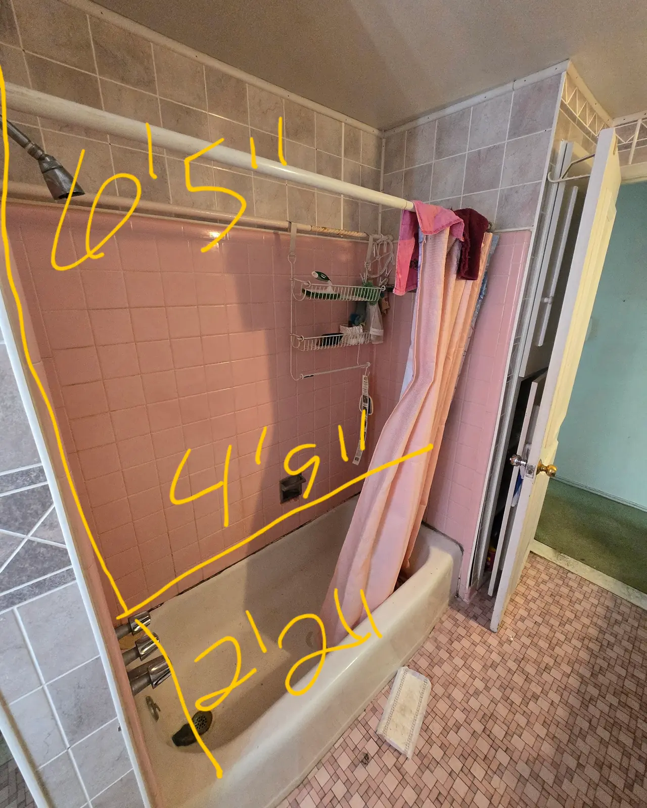 Tub with pink wall tile and a shower curtain, marked with handwritten measurements, before
