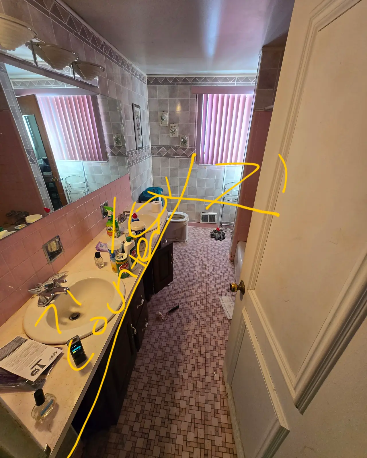 Long vanity counter with a wall mirror, marked with handwritten measurements, before